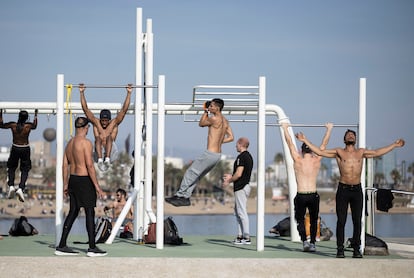 Jóvenes hacen deporte sin camiseta en el gimnasio del Espigó del Gas de Barcelona.