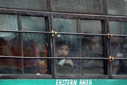 Viajeros observan caer la lluvia a través de las ventanillas de un autobús en Srinagar (India).