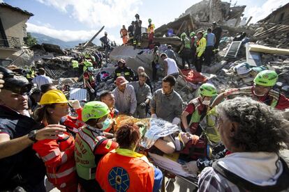 Mulher é transportada em uma maca pelas equipes de resgate, em Amatrice (Itália).