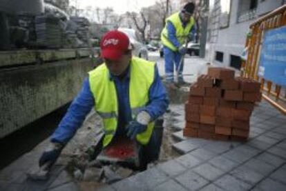 Un trabajador haciendo obras en una acera de Madrid.