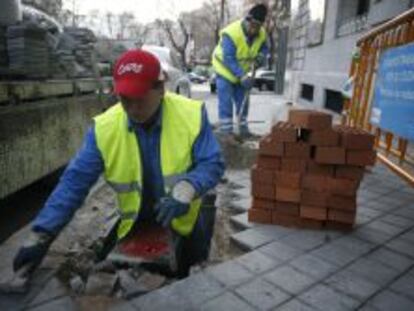 Un trabajador haciendo obras en una acera de Madrid.