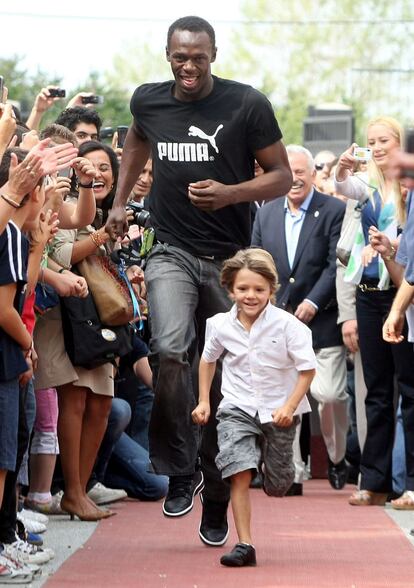 El jamaicano Usain Bolt compite con un niño en el patio de un colegio, durante la tradicional bendición que da comienzo al año nuevo en Tesalónica, al norte de Grecia