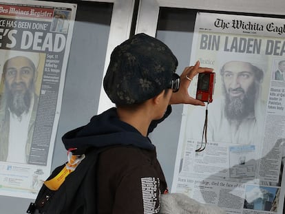 Una transeúnte fotografía las portadas del día expuestas en el Newseum, el museo del periodismo de Washington.