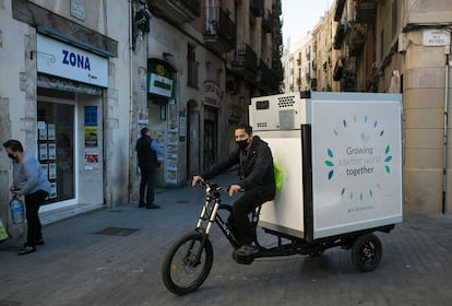Un repartidor distribuye pan congelado para supermercados de Ciutat Vella con una bicicleta de carga eléctrica.