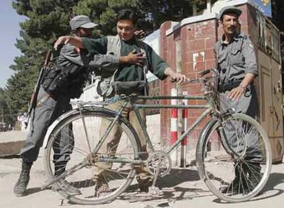 Un policía local cachea a un civil, ayer en Herat, tercera ciudad en importancia de Afganistán.