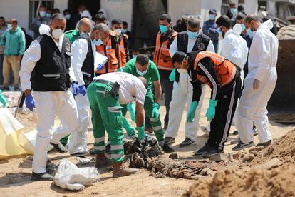 Miembros de los ministerios palestinos de interior, salud y justicia examinan los cuerpos recuperados entre las ruinas del hospital Al Shifa, tras el abandono de las tropas israelíes, este lunes en Gaza.