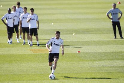 Xabi Alonso dribbles the ball in front of coach José Mourinho and teammates during a Real Madrid training session.