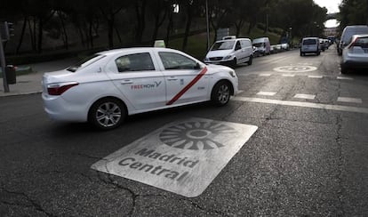 Un taxi pasa por una señal de Madrid Central.