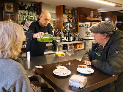 Felipe Ferreiro sirviendo vino por copas a unos parroquianos