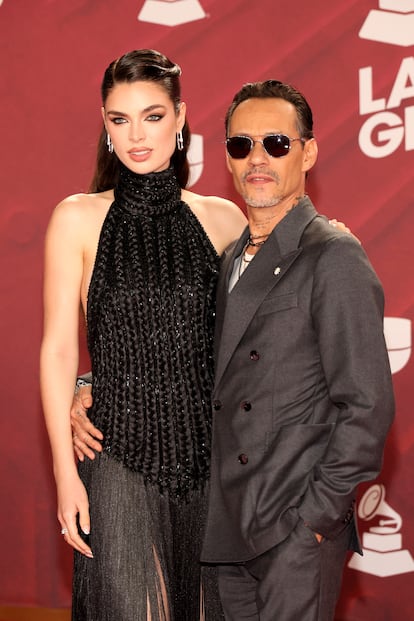 Nadia Ferreira, con vestido negro cuello halter, junto a su marido Marc Anthony, con traje gris.