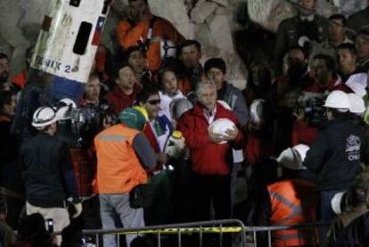 Luis Urzúa, el último de los mineros en salir, celebra el fin del rescate cantando con el presidente el himno de Chile.