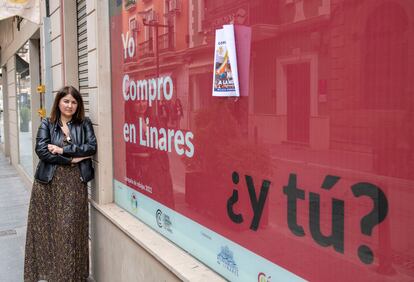 Raquel Pantoja, extrabajadora de El Corte Inglés de Linares, despedida hace un año, ante un cartel sobre el pequeño comercio.