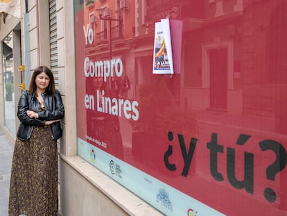 Raquel Pantoja, extrabajadora de El Corte Inglés de Linares, despedida hace un año, ante un cartel sobre el pequeño comercio.