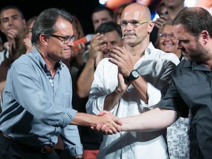 Artur Mas (e) i Oriol Junqueras (d) s'encaixen la mà davant de Raül Romeva.