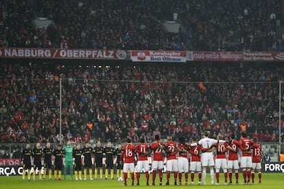 Los jugadores del Atlético de Madrid y del FC Bayern Munich, durante el minuto de silencio, antes del partido, en memoria de los miembros del equipo de fútbol brasileño Chapecoense.