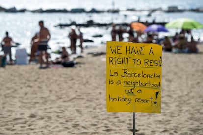 "Tenemos el derecho de descansar. La Barceloneta es un barrio, no un resort de vacacciones" Pancarta en inglés clavada en la playa de la Barceloneta durante la protesta. 