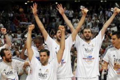 Los jugadores del Real Madrid celebran la victoria ante el Barcelona Regal en el quinto y definitivo partido de la final de la Liga ACB, disputado esta noche en el Palacio de los Deportes, en Madrid.