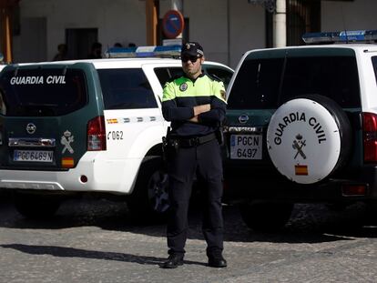 Agente de la Guardia Civil junto a dos vehículos del cuerpo.