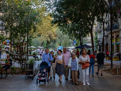 Vecinos paseando en la calle de Consell de Cent de Barcelona, este jueves por la tarde.