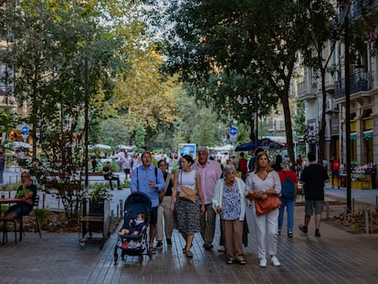 Vecinos paseando en la calle de Consell de Cent de Barcelona, este jueves por la tarde.