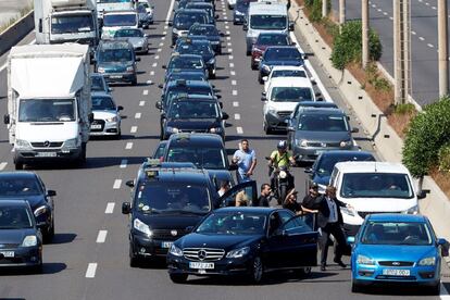 Cientos de taxistas participan en la marcha lenta desde al aeropuerto de El Prat hasta el puerto de Barcelona por la Ronda Litoral, en la segunda jornada de huelga en protesta por la suspensión cautelar del reglamento metropolitano que regula las licencias VTC. En la imagen, un grupo de taxistas se enfrentan a un conductor de VTC.