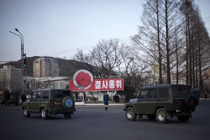 Una polic&iacute;a de tr&aacute;fico, en una calle de Pyongyang en la que hay una pancarta en la que se lee &quot;Defendernos hasta la muerte&quot;.