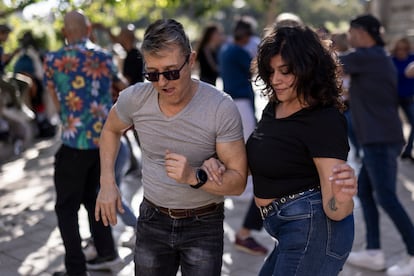 Una pareja de bailarines junto a la cascada del parque de la Ciutadella durante una sesión de danza al aire libre.