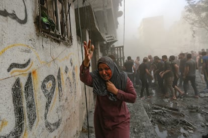 Una mujer palestina herida corre tras los ataques aéreos israelíes que tuvieron como objetivo su vecindario en la ciudad de Gaza, este lunes.