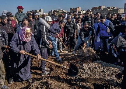 Familiares y amigos de Ayub Mabruk cubren de tierra su fosa en el cementerio de Salé, en Marruecos.