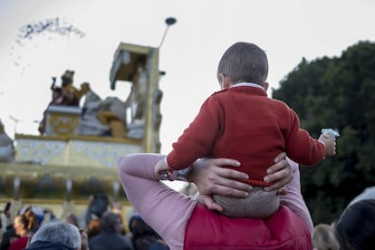 Un niño ve la cabalgata de Sevilla subido en los hombros de su padre.