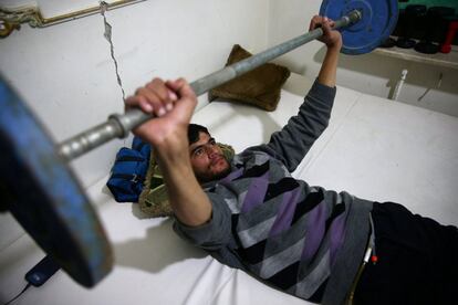 Ayman, de 24 años, levanta pesas como parte de su entrenamiento para rehabilitarse de su lesión de médula espinal en el centro de rehabilitación de Douma, en Damasco (Siria).