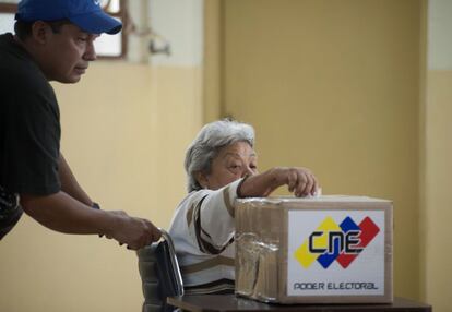 Una electora en silla de ruedas deposita su papeleta en el barrio caraqueño de 23 de enero.