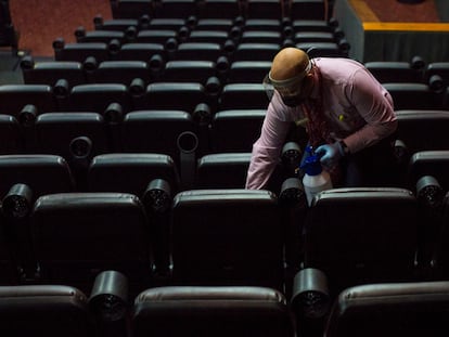 Funcionário limpa os assentos de uma sala de cinema em Caracas, na quarta-feira.