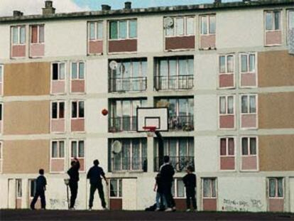 Un grupo de jóvenes juega al baloncesto en un barrio periférico de París.