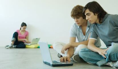 Tres adolescentes navegan por internet en una sala WiFi