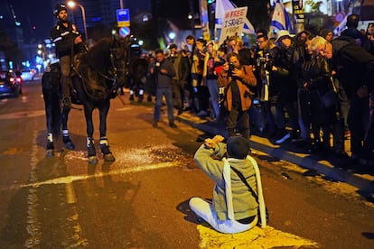 Una mujer se planta sobre el asfalto desafiando a uno de los agentes a caballo que obligaba a los manifestantes a subirse a la acera para que pudiera seguir la circulación de vehículos.