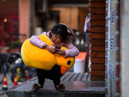 Una mujer usa su m&oacute;vil en las calles de Shangh&aacute;i. 