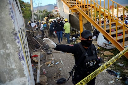 Un policía resguarda la zona donde ocurrió el accidente. La mayoría del centenar y medio de migrantes que viajaban en el camión eran guatemaltecos, según ha confirmado el embajador de este país en México. Se dirigían hacia Veracruz para unirse a la caravana que va en dirección a Puebla y Ciudad de México.