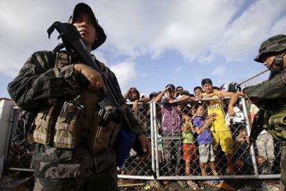 Soldados filipinos aseguran el perímetro de seguridad durante el reparto de ayuda humanitaria a los damnificados por el huracán "Haiyan", en el exterior del aeropuerto de la ciudad de la ciudad de Tacloban, en la provincia de Leyre.