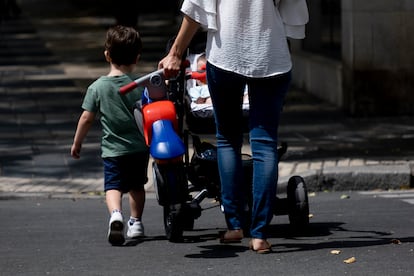Una mujer pasea con dos niños por el centro de Sevilla.
