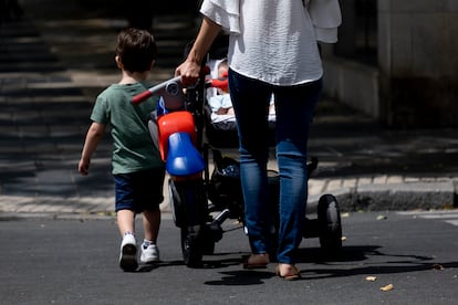 Una mujer camina con dos niños en Sevilla.