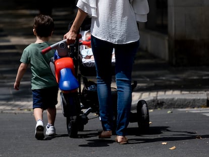 Una mujer pasea con dos niños por el centro de Sevilla.