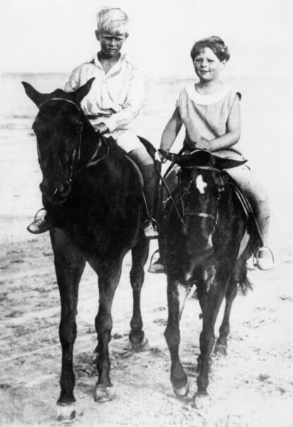 Felipe de Edimburgo, a la izquierda, en Rumania en 1928 junto a Miguel de Rumania, rey desde el año anterior por la muerte de su abuelo (y la huida de su padre, el heredero Carlos, con su amante). Cuando le preguntaban al duque de Edimburgo qué idioma se hablaba en su casa, solía contestar: “¿Qué casa?”. Llevado a Francia con un año, su familia se instala a las afueras de París, donde asiste a una escuela estadounidense. Será poco el tiempo que viva con los suyos: sus hermanas (la mayor le lleva 16 años y siete la pequeña) se casan, su madre es internada en un psiquiátrico y con su padre, jugador y mujeriego, tendrá escasa relación a lo largo de su vida.