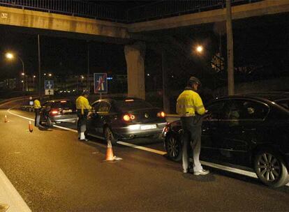 Tres guardias civiles de Tráfico realizan un control de alcoholemia en el kilómetro 45 de la M-40, a la altura de Pozuelo de Alarcón.