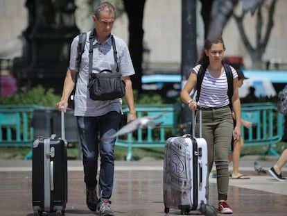 Turistas con maletas por el centro de Barcelona.