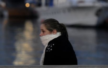 Una joven se protege en Barcelona del intenso frío de la ciudad.