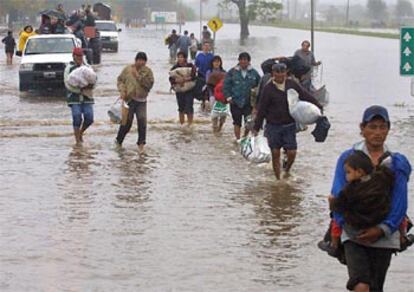 Un grupo de personas abandona la ciudad de Santa Fe debido a las inundaciones.