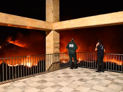 Guardias civiles contemplan el fuego de Ceuta, esta mañana.