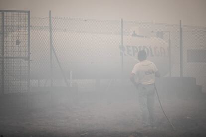 El consejero de Medio Rural de la Xunta de Galicia ha alertado de que los incendiarios no saldrán impunes: “Tenemos muchos medios, mucha tecnología, y van a tener que pagar no solo con penas de cárcel, si se demuestra esa intencionalidad, sino con su patrimonio”. En la imagen, un vecino refresca un tanque de gas en Cualedro, este lunes.