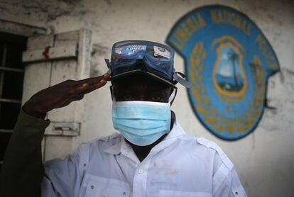 Un policía liberiano espera a tomar la temperatura a los viajeros que llegan a la estación de West Point, en Monrovia.